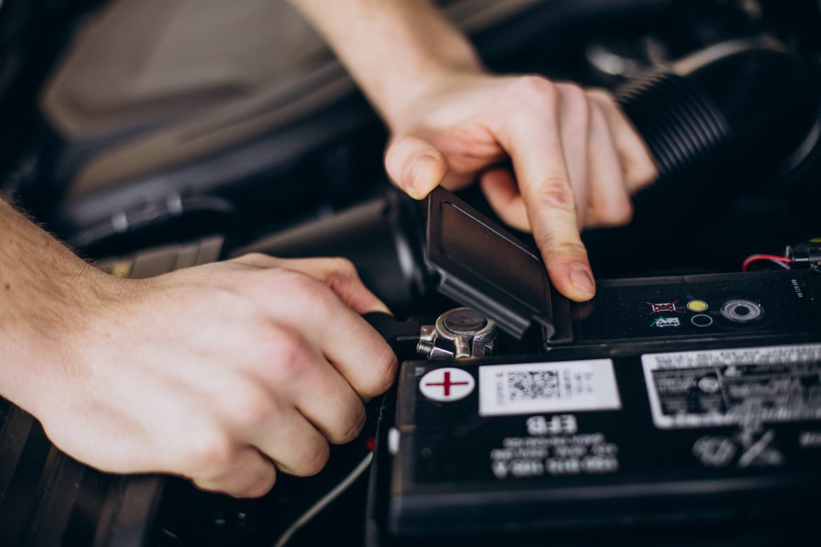 Automotive battery installed in a car engine bay